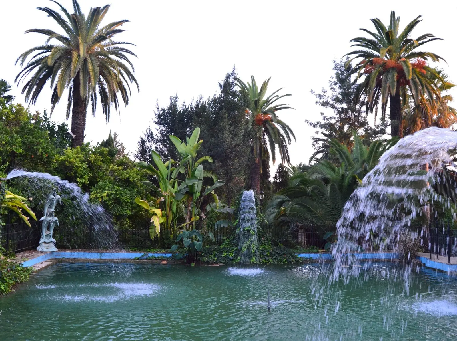 Estanque con surtidores y cascadas entre palmeras en los jardines de la hacienda