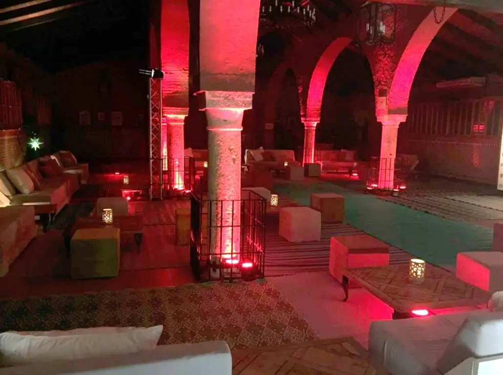 Sofás blancos y arcos iluminados de rojo: la zona de copas, de noche